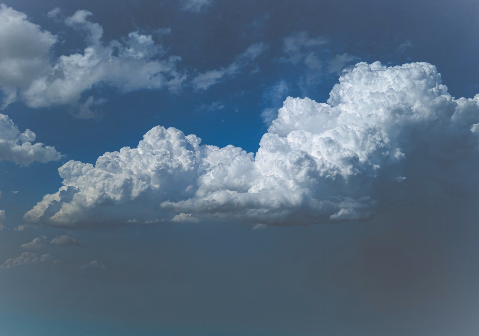Un cumulo si illumina di bianco argenteo in un cielo blu scuro della sera.